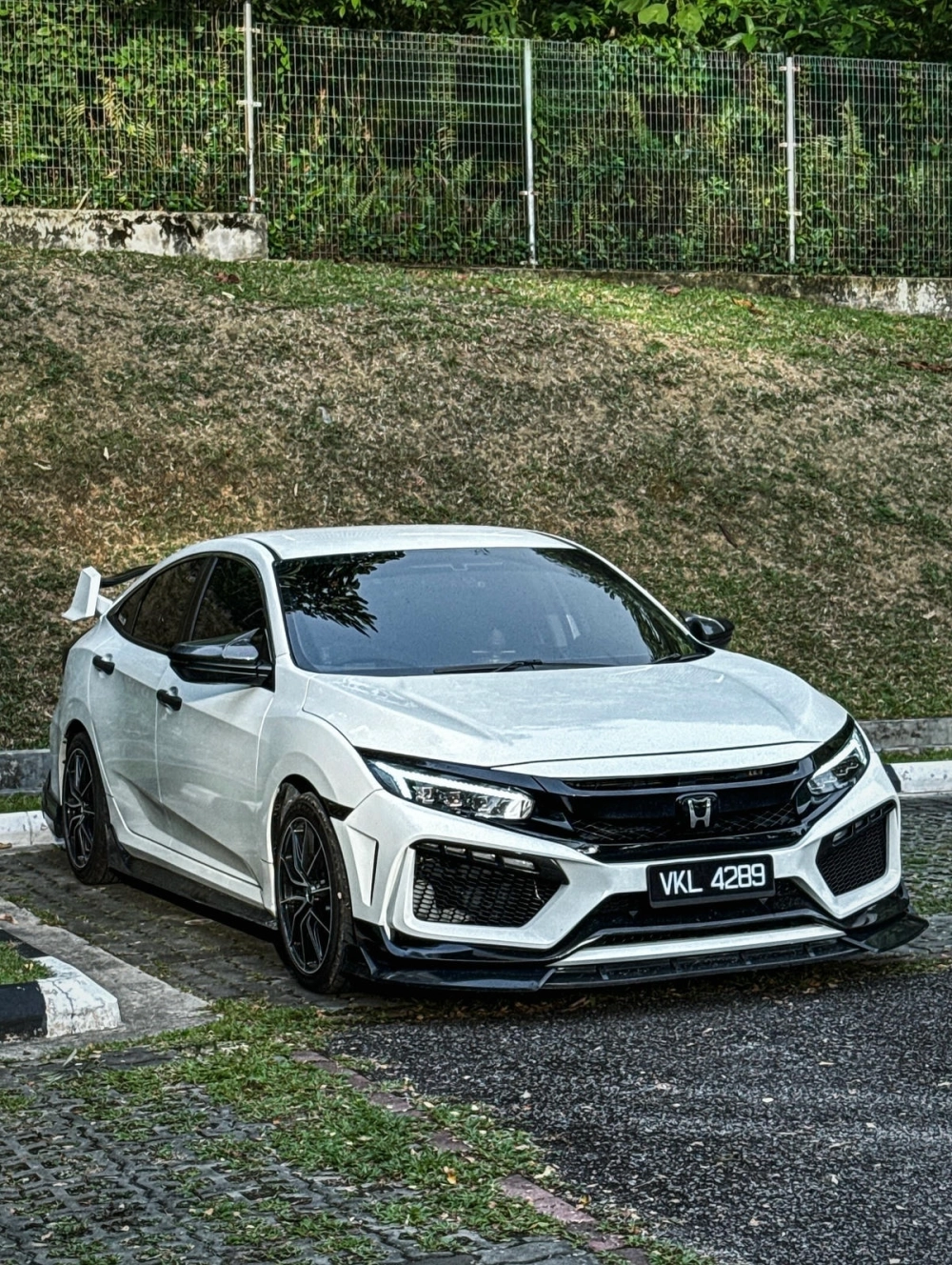 Honda Civic độ mâm đen đa chấu thể thao trên nền cỏ xanh mát