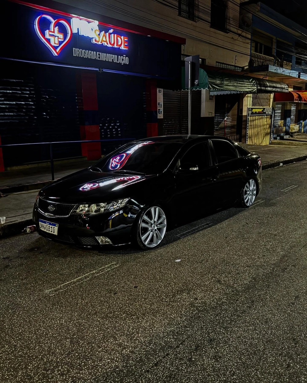 Xe đen Kia K3 độ mâm bạc đa chấu sáng bóng trong đêm tối