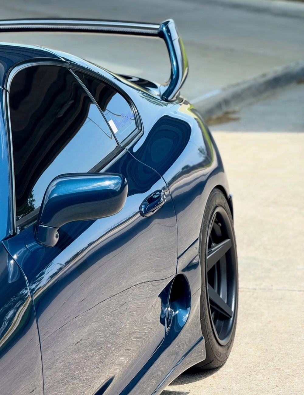 Góc nghiêng xe thể thao xanh độ mâm lồi 5 chấu đen đầy mạnh mẽ