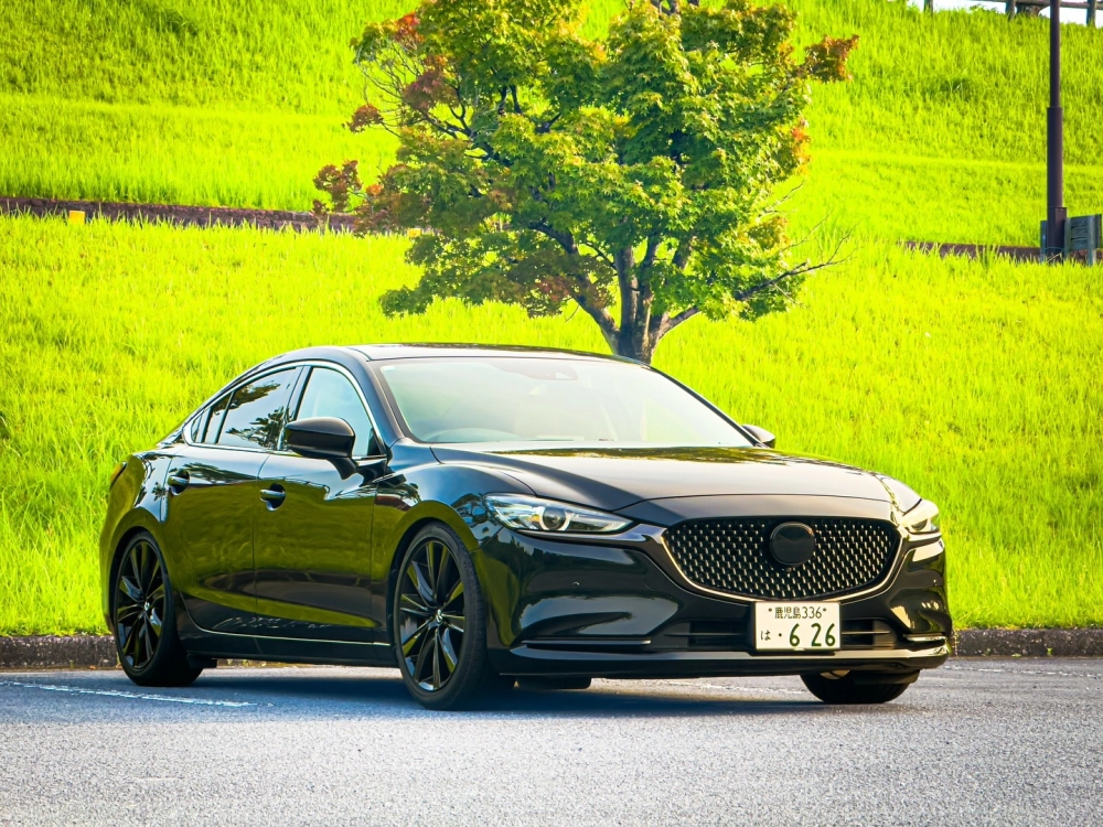 Xe Mazda 6 độ mâm đa chấu bạc sang trọng bên tòa nhà xanh